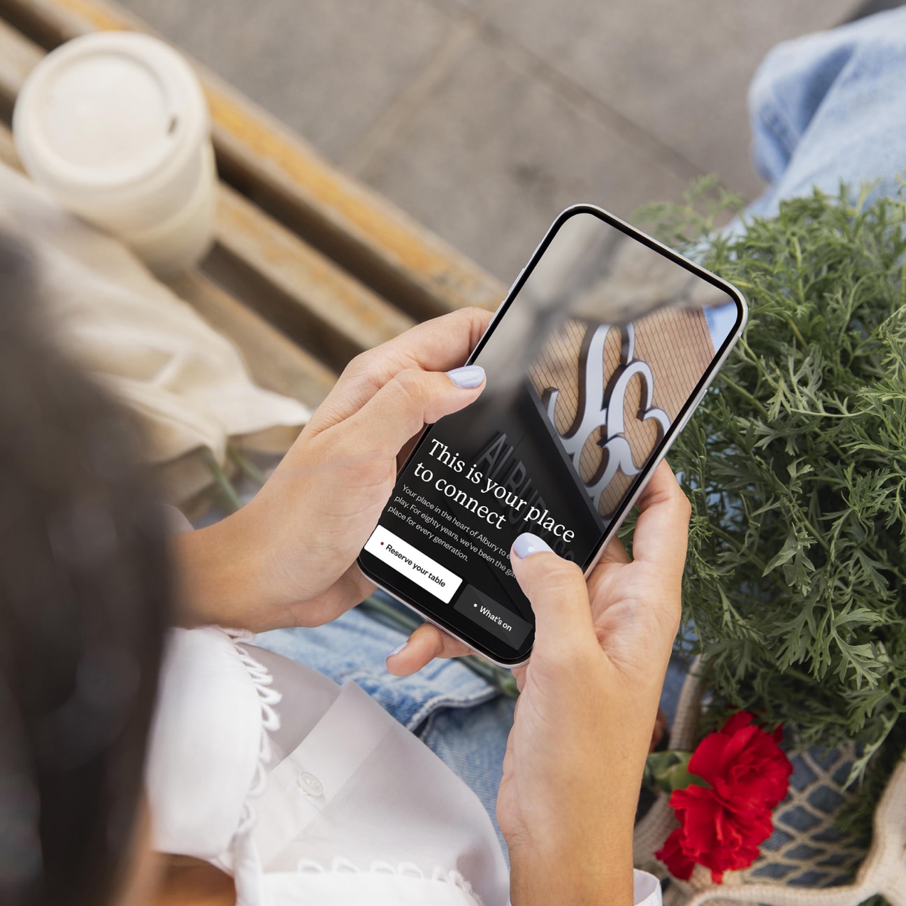 SS&A Club homepage held in hand on a phone mockup